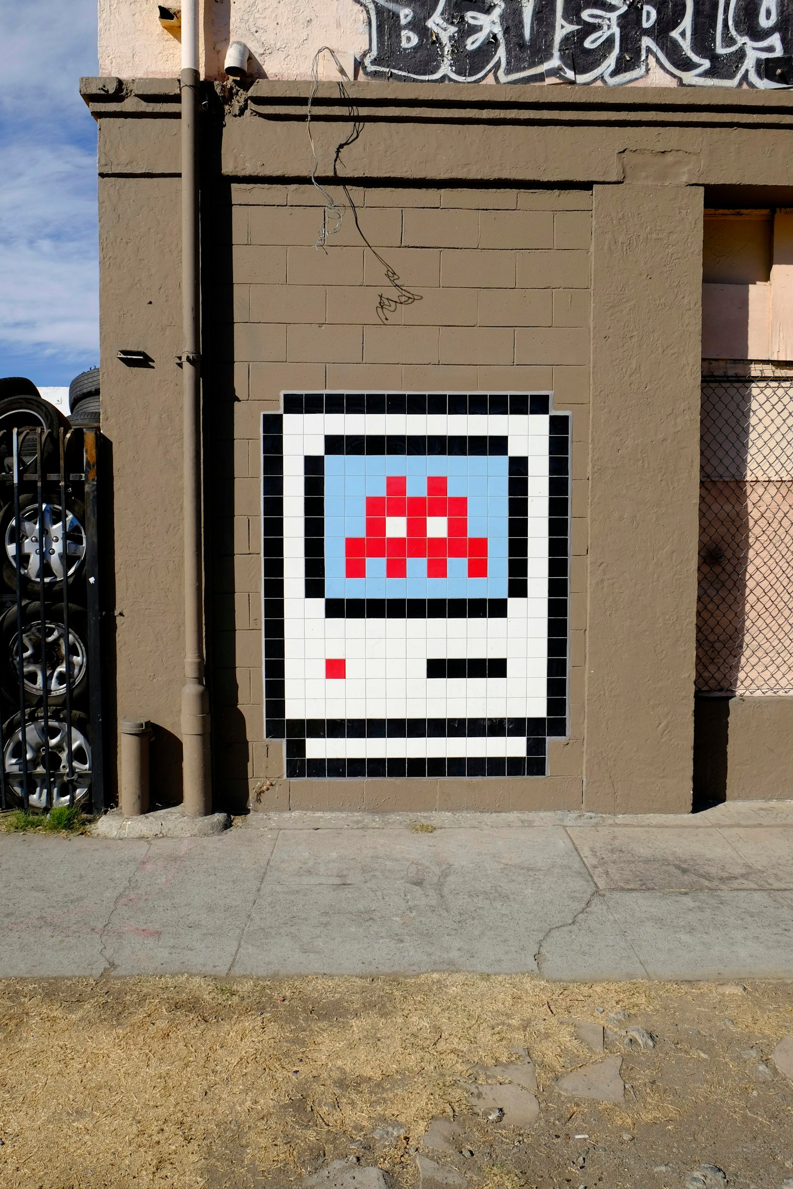 A pixel mosaic set into a street wall.