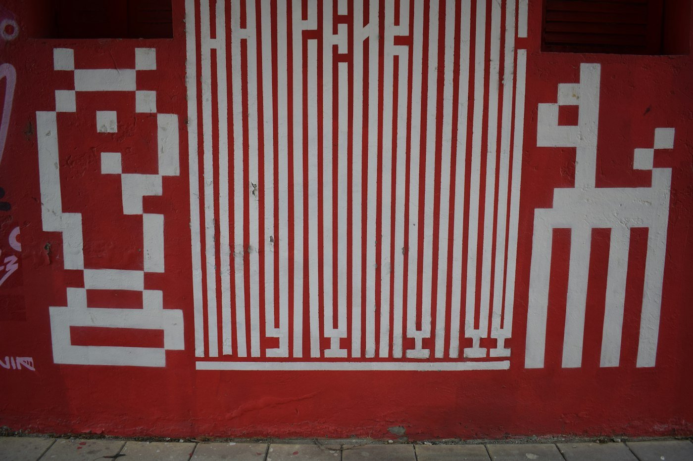 White pixel figures on a red wall.